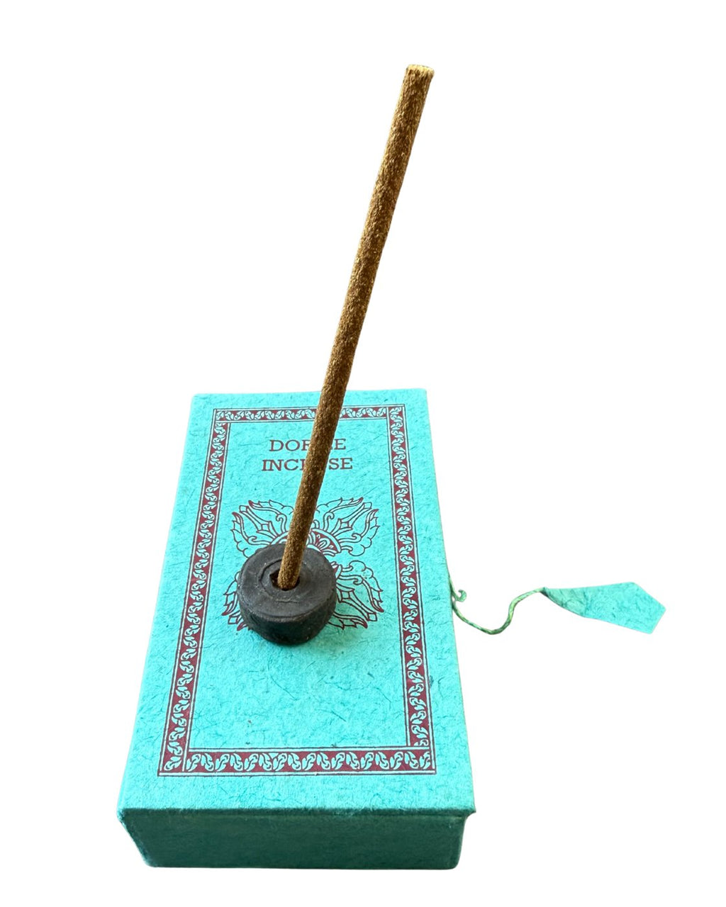 Stupa Dorjee incense stick lit in its holder on a turquoise lokta paper box